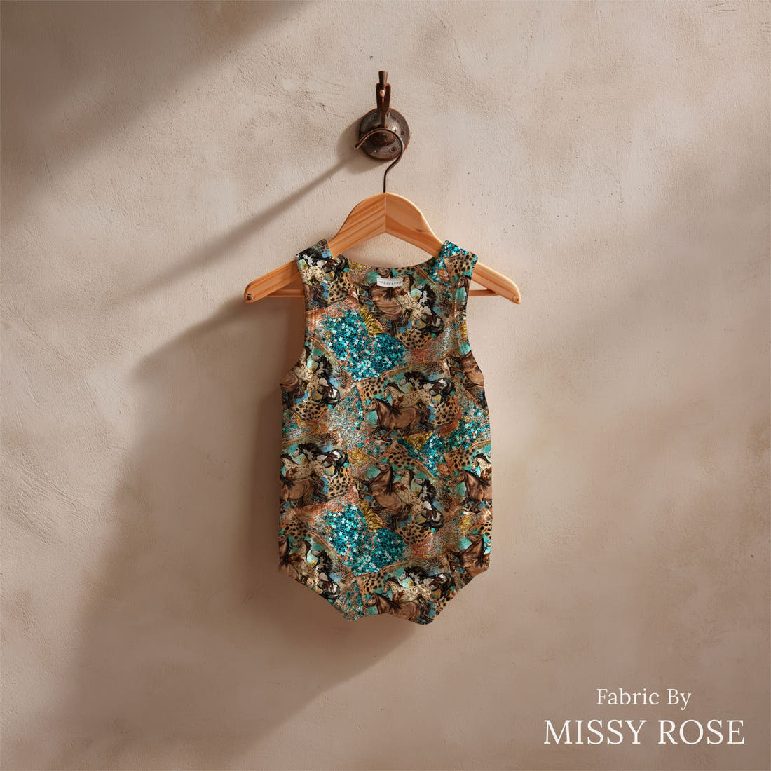 Design 1025 Teal Horses Fabric sewn into a baby romper – see how the print looks made up | Fabric by Missy Rose