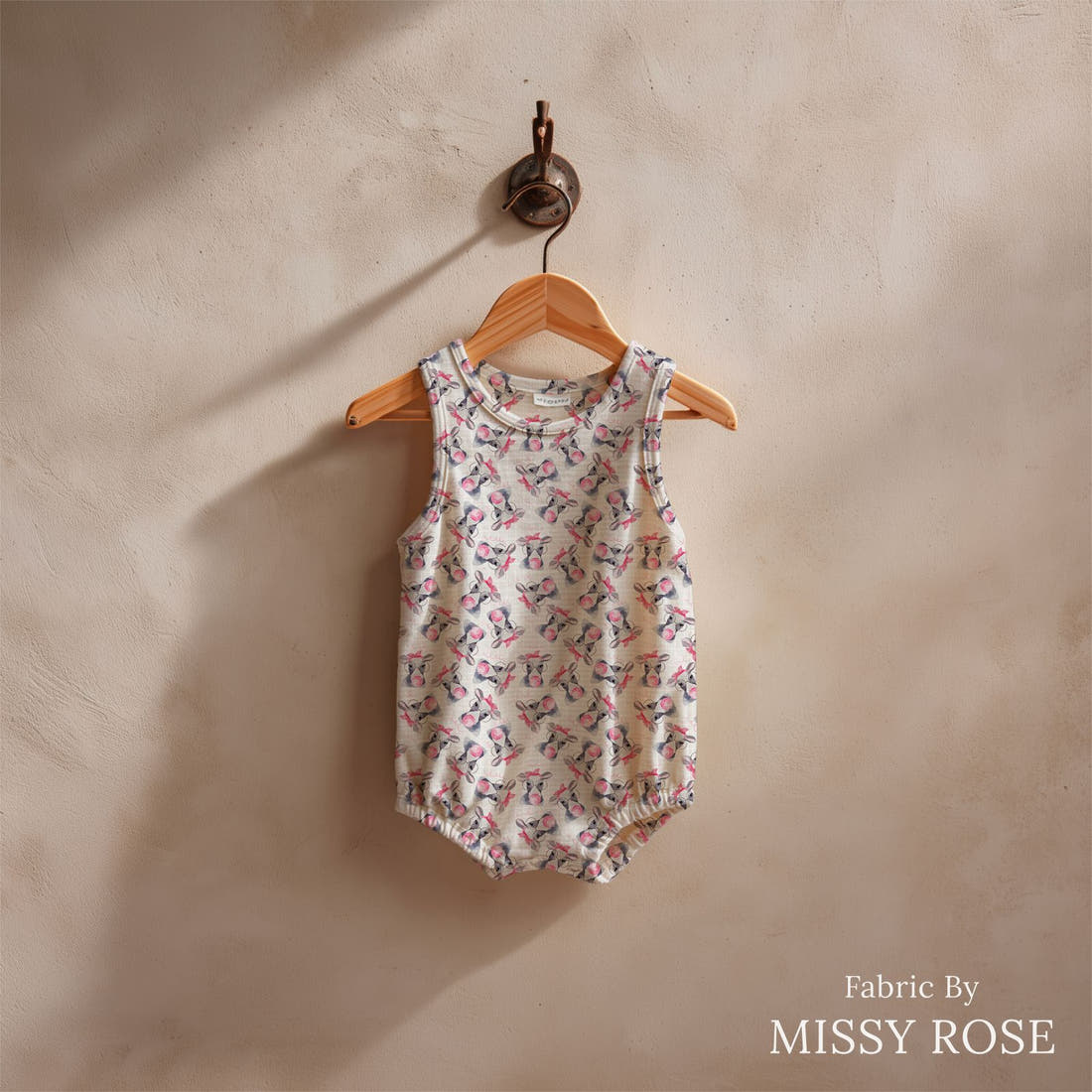 Design 971 Cow Bubble Gum Fabric sewn into a baby romper – see how the print looks made up | Fabric by Missy Rose